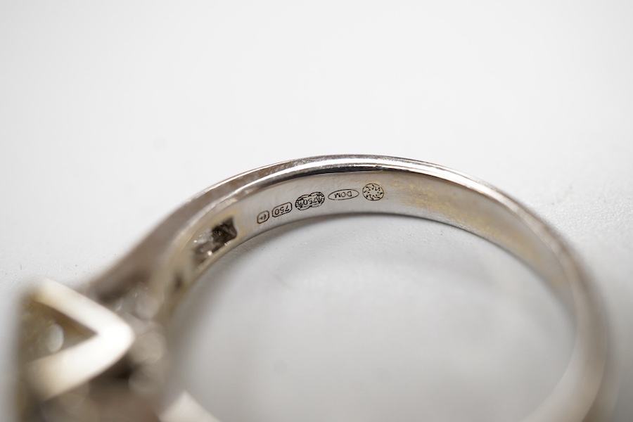 A diamond ring, set with a princess-cut diamond weighing approximately 0.40 carats, to shoulders channel-set with smaller princess-cut diamonds totalling approximately 0.40 carats, mounted in 18ct white gold, size K1/2,